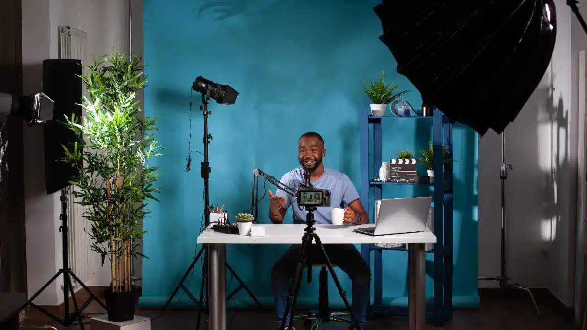 Tânără la birou într-un setup de filmare, cu lumini video în fundal