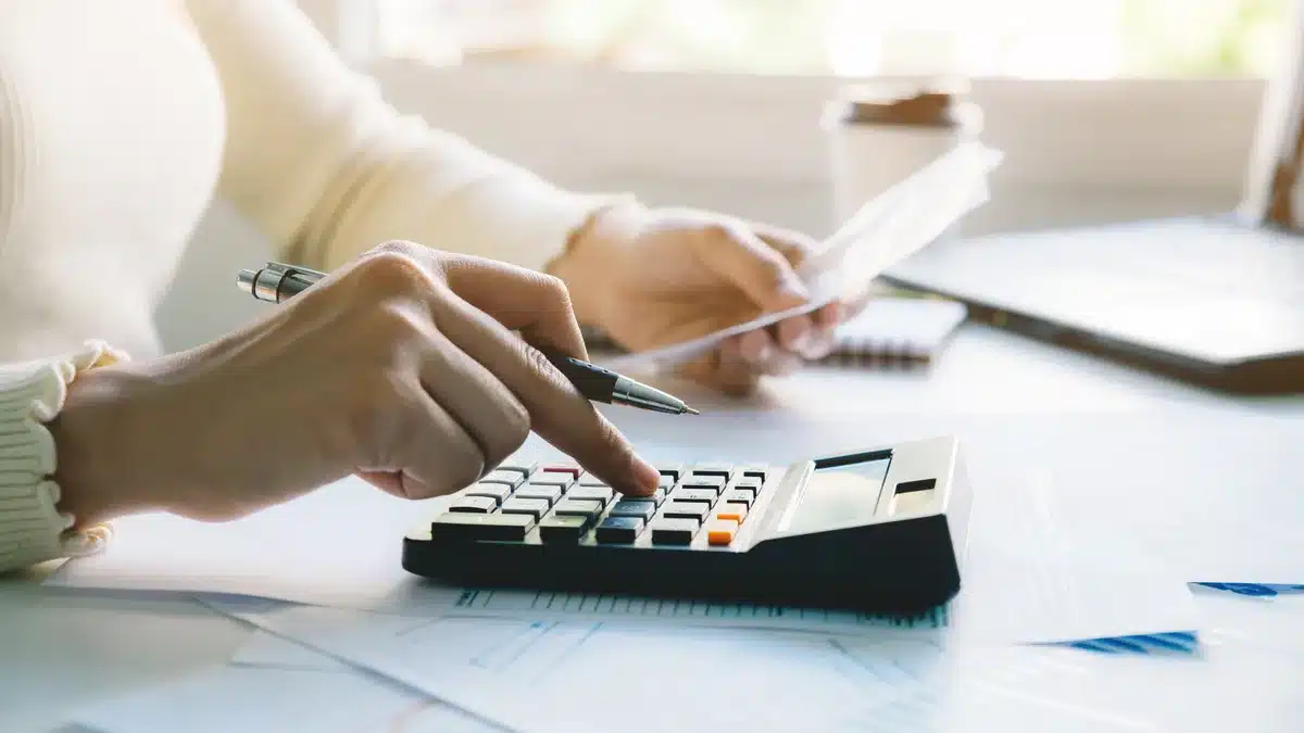 Femeie care calculează taxele și contribuțiile datorate pentru veniturile din videochat