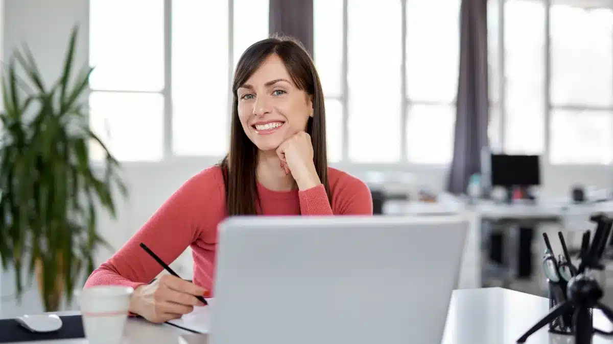 Model zâmbind în fața laptopului, urmărind creșterea ranking-ului și a bonusurilor pe platformele de videochat
