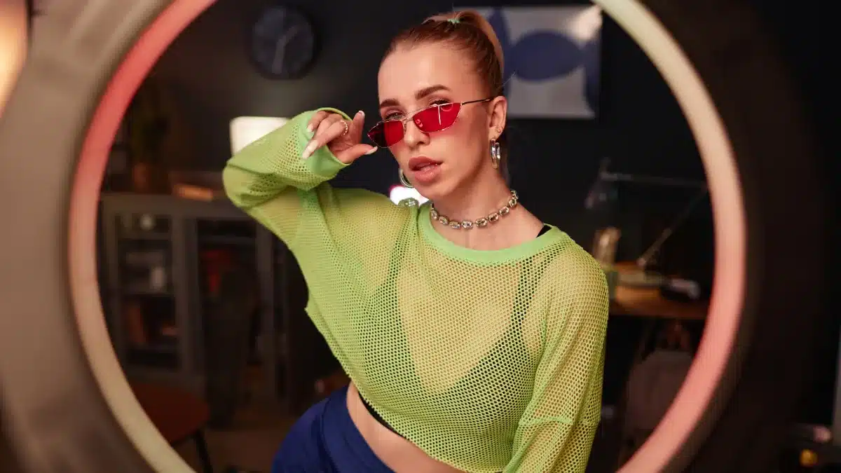 Tânără modelă filmând printr-un ring light în timpul unei sesiuni live de videochat