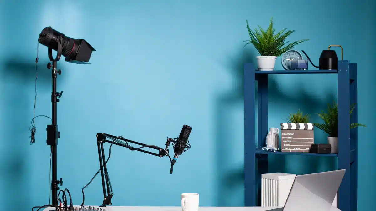 Cameră de filmat profesională, cu microfon, lumini și birou alb — echipamentul unei camere dintr-un studio de videochat